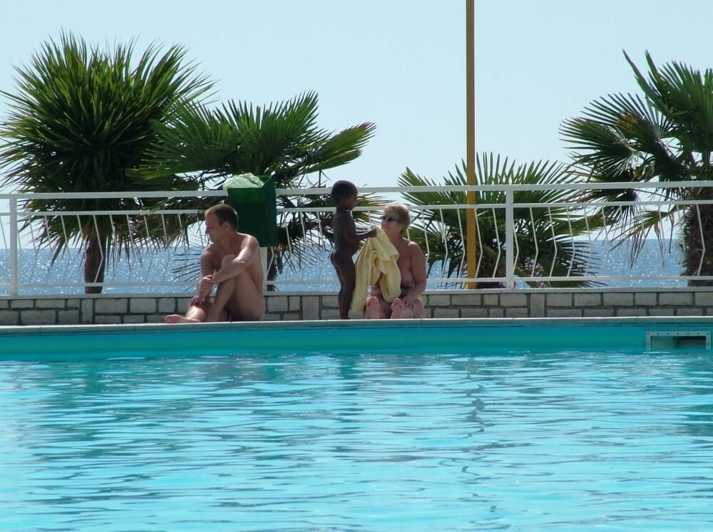 Photo of naturists in an outdoor pool - Naturists love sunlight and fresh air